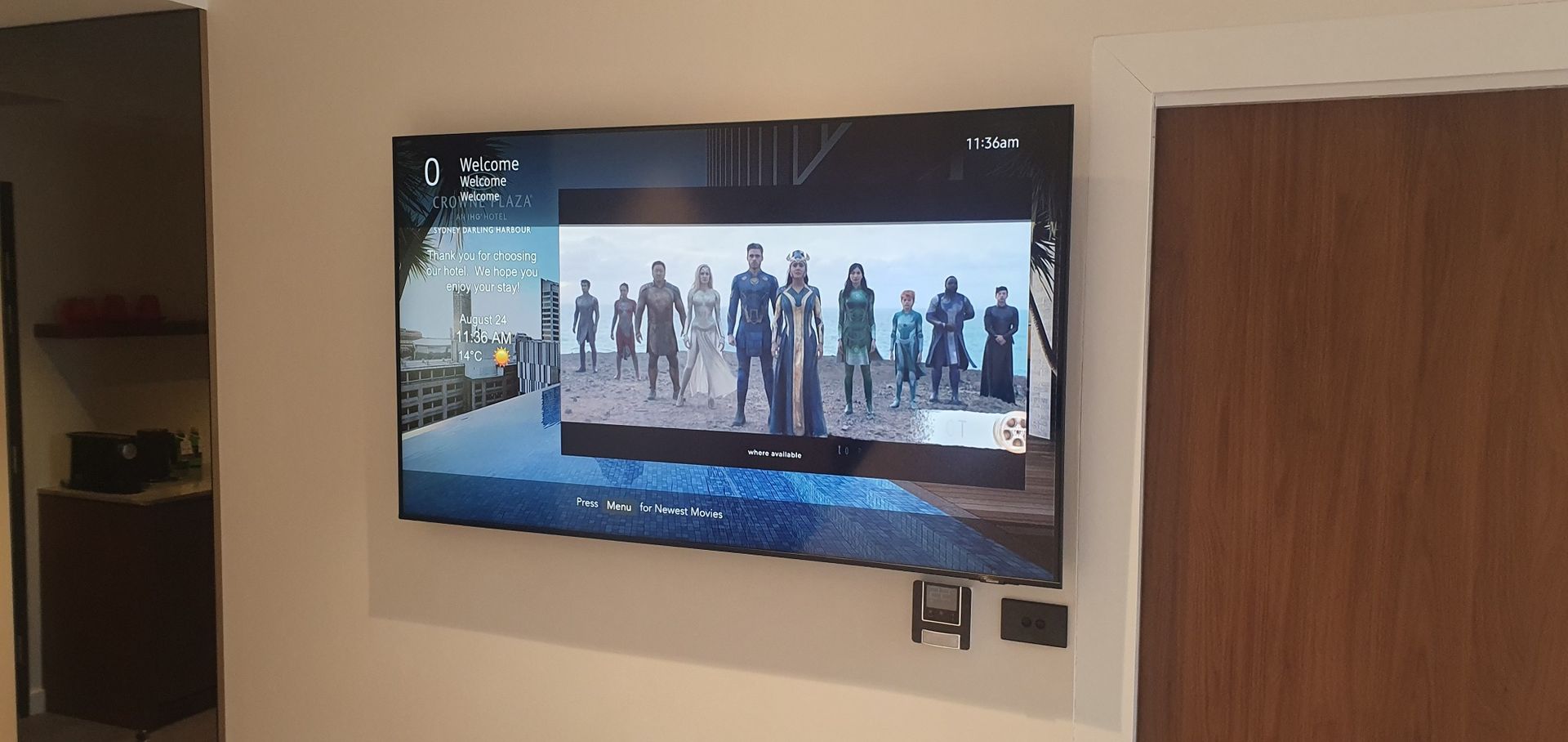 Wall-mounted hotel guest room display showing an integrated entertainment and information interface.