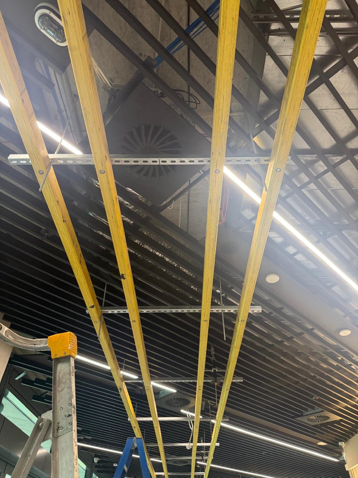 Ceiling batten framing and exposed services being installed ahead of the LED and signage fit-out.